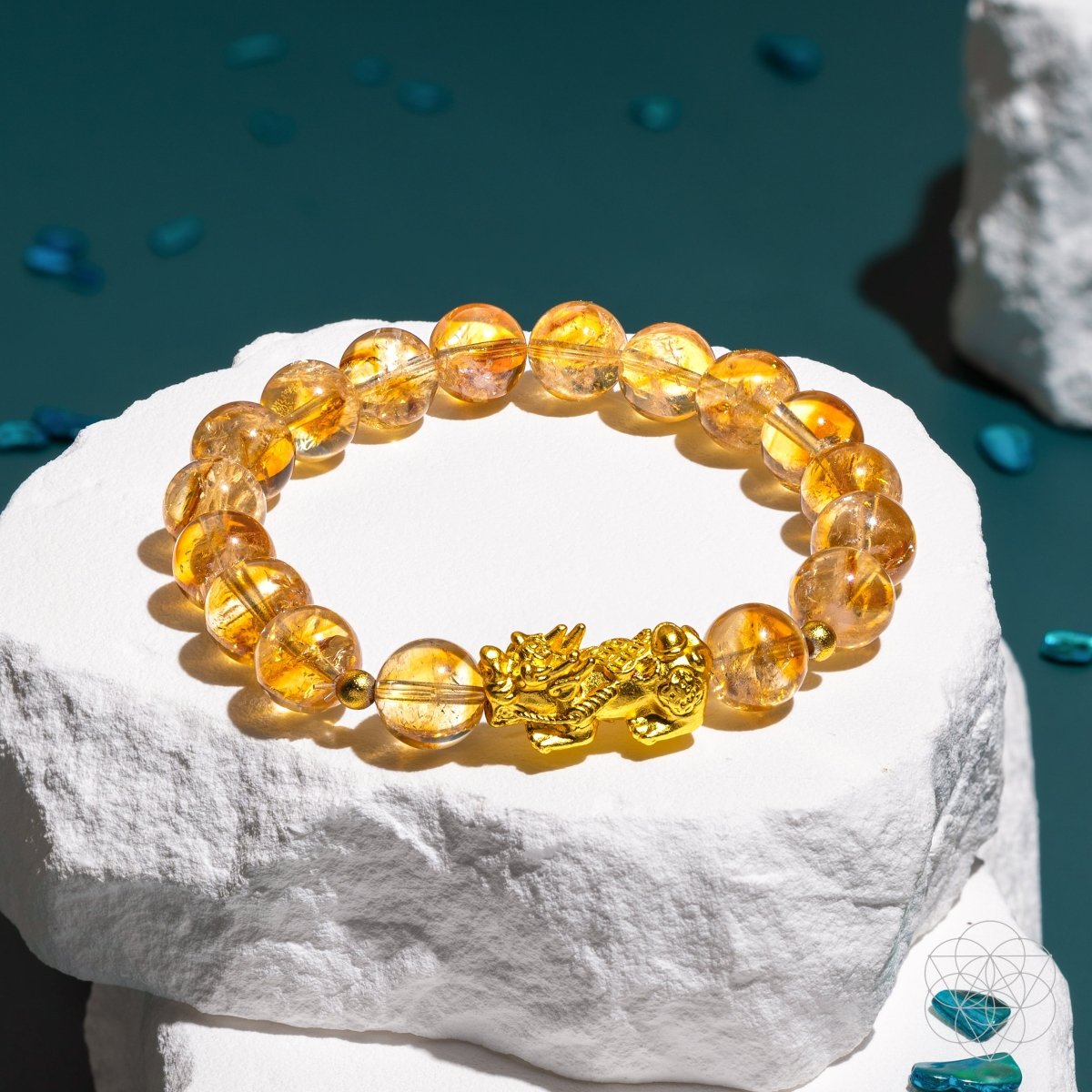 Conscious Items feng shui citrine bracelet with round golden beads and dragon charm on white stone